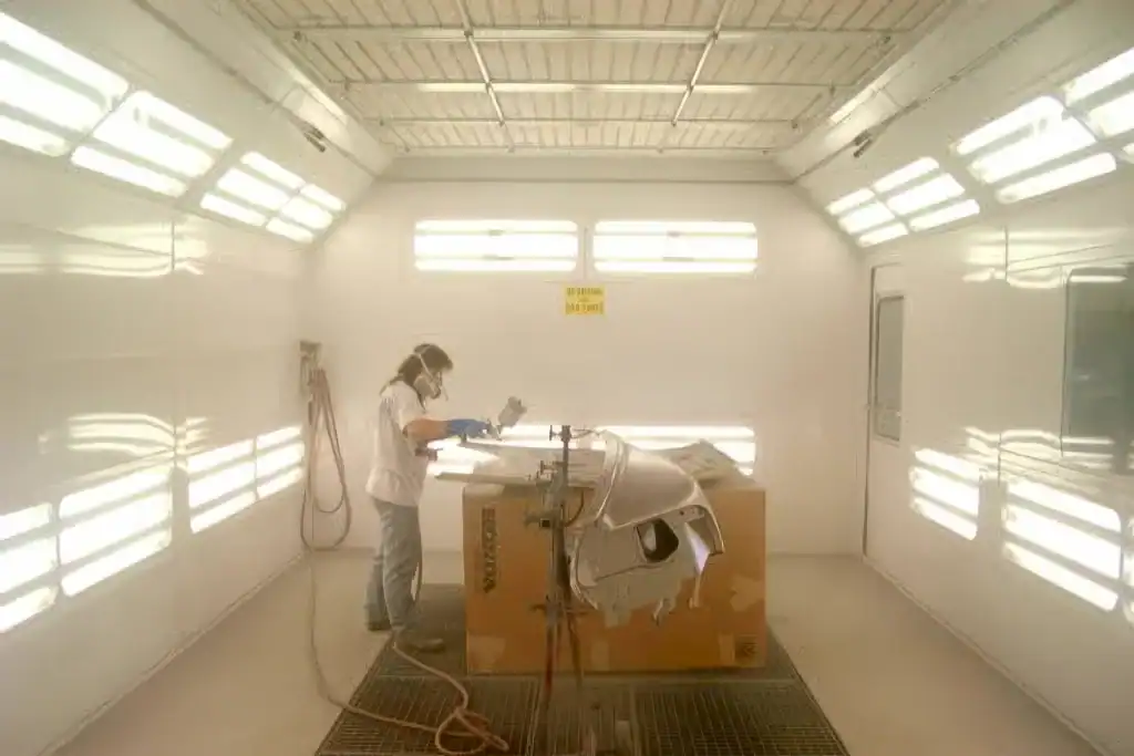 Painting an auto body part inside the paint booth at McCarthy's Auto Body - Cleveland OH